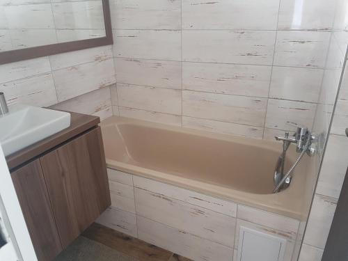 ein Badezimmer mit einer Badewanne und einem Waschbecken in der Unterkunft Apartmány u skanzenu in Rožnov pod Radhoštěm