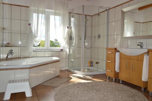 La salle de bains blanche est pourvue d'une baignoire, d'un lavabo et d'une chambre. dans l'établissement Ferienhaus Eifel, à Nettersheim