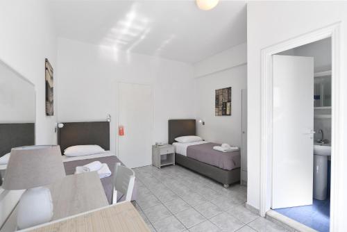 a room with two beds and a table and a mirror at Villa Katerina in Parikia