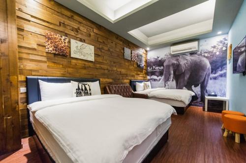 una camera con 2 letti e un murale a tema elefante di Bellis a Luodong