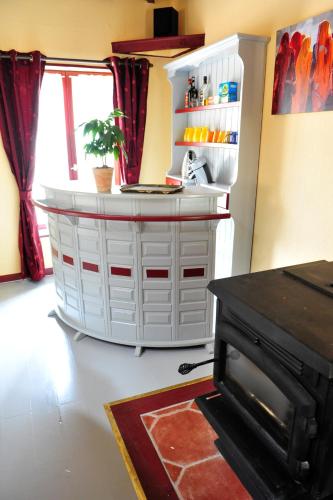 une armoire blanche dans une pièce avec une cheminée dans l'établissement Chez Gillou, à Boën