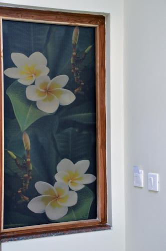 a picture of flowers in a picture frame on a wall at Hotel Raams Park in Tiruchchirāppalli