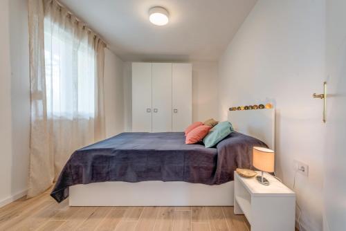 a white bedroom with a large bed and a window at Beach House Lana in Slatine