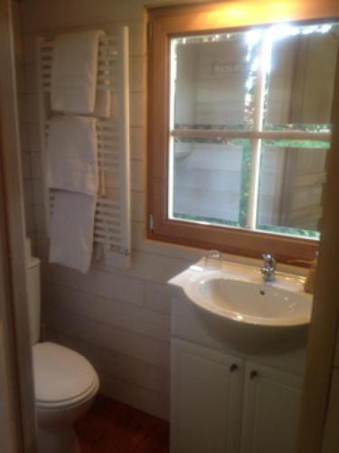 une salle de bain avec un lavabo et des toilettes et une fenêtre dans l'établissement Les Roulottes de la Baronnie, à Saint-Malo