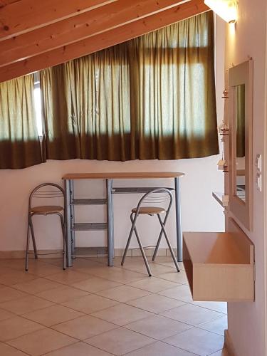 a table and two chairs in a room at Ionion Studios in Kanali