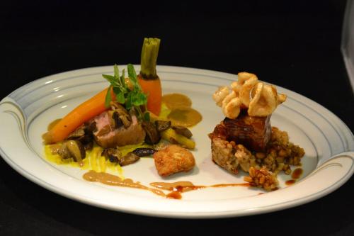 a plate of food with meat and vegetables on a table at Hotel Erhart Sölden in Sölden