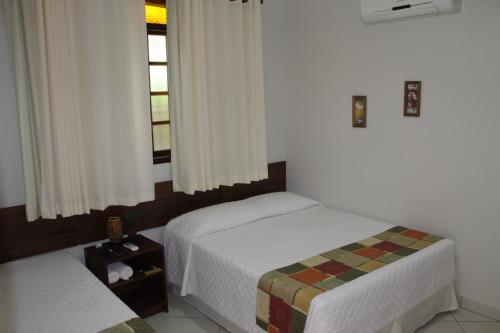 a bedroom with two beds and a window at Pousada Luar da Serra in Conservatória