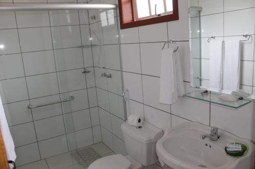 a bathroom with a shower and a toilet and a sink at Pousada Luar da Serra in Conservatória