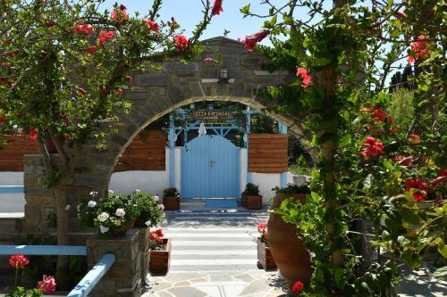 an entrance to a building with a blue door and flowers at Villa Katerina in Parikia