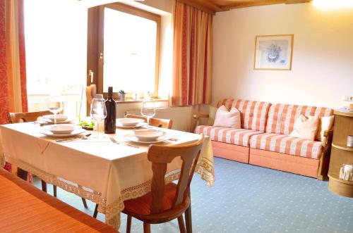- un salon avec une table et un canapé dans l'établissement Landhaus Schmitte, à Biberwier