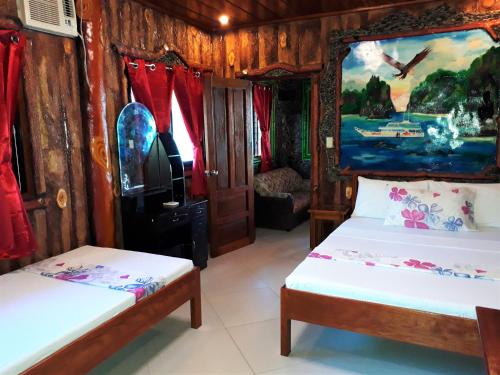 a room with two beds and a painting on the wall at Ausan Beach Front Cottages in San Vicente