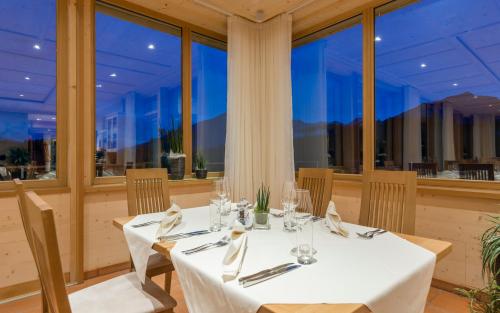 a dining room with tables and chairs and windows at Hotel Jonathan in Naz-Sciaves