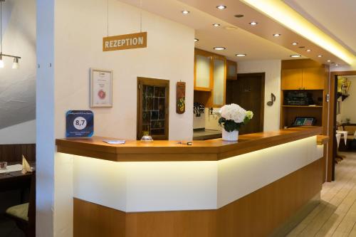 a reception counter at a hospital with flowers on it at Landgasthof Zum Stern in Hammelburg- Obererthal