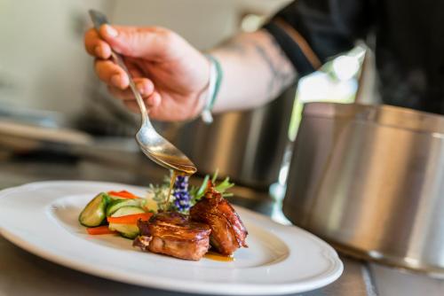 a person eating a plate of food with a fork at Hotel Jonathan in Naz-Sciaves