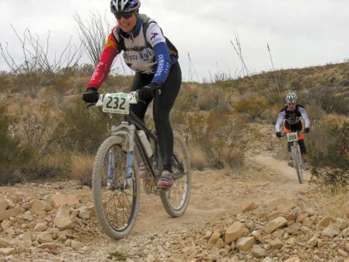 two people riding bikes on a dirt trail at Terlingua Ranch Lodge in Terlingua