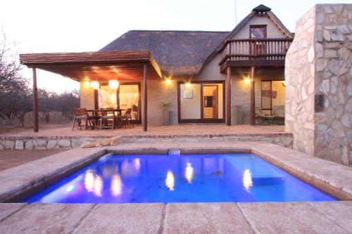 a swimming pool in front of a house at Zebra Lodge & Giraffe Lodge in Hoedspruit