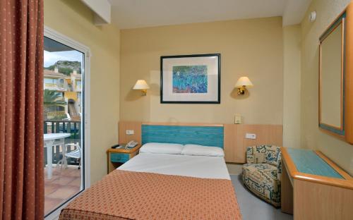 a small bedroom with a bed and a window at Sol Milanos Pingüinos in Son Bou