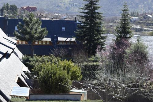 a view of a house with trees and a building at La Casita de la Sierra Cercedilla in Cercedilla
