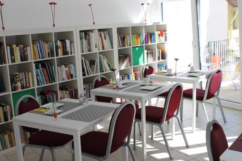two tables and chairs in a library with bookshelves at Zum Löwen in Bad Homburg vor der Höhe