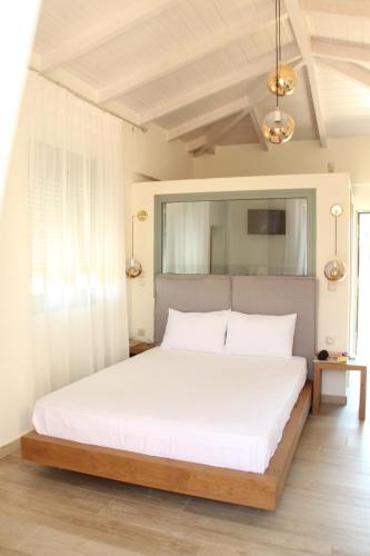 a bedroom with a large bed with white sheets at Olga Lounge Hotel in Lygia