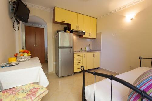 cocina con armarios amarillos y nevera en Apartman Pelcic,with WiFi and free parking en Kostrena