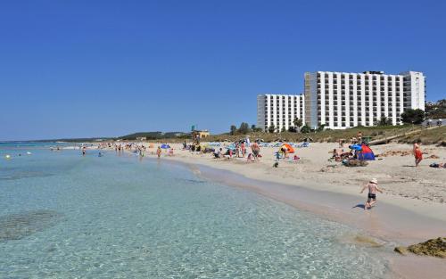 a group of people on a beach with the ocean at Sol Milanos Pingüinos in Son Bou