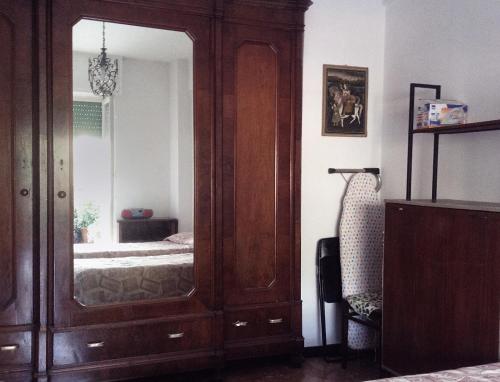 a bedroom with a large wooden cabinet with a mirror at Condominio Marina in Rapallo
