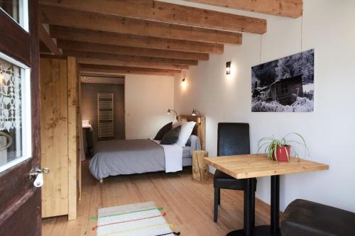 a bedroom with a bed and a wooden table at La Foyère in Aime-La Plagne