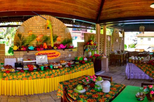 un chiosco di cibo in un ristorante con due tavoli di Hotel Pousada Porto do Colibri a Porto De Galinhas