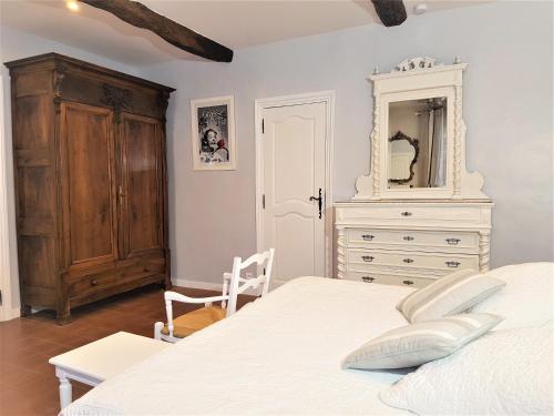 a bedroom with a bed and a dresser and a mirror at B&B with charm, quiet, kitchen, sw pool. in Grasse