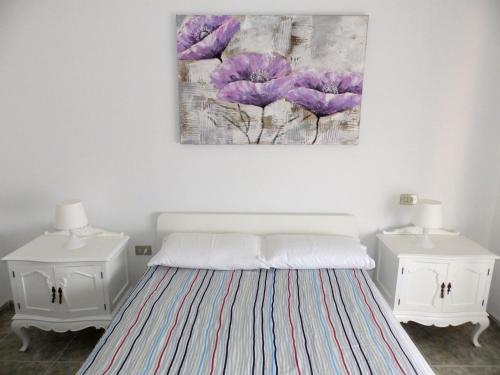 エル・メダノにあるApartamentos Medano - Casa Playaの紫色の花が描かれた壁のベッドルーム