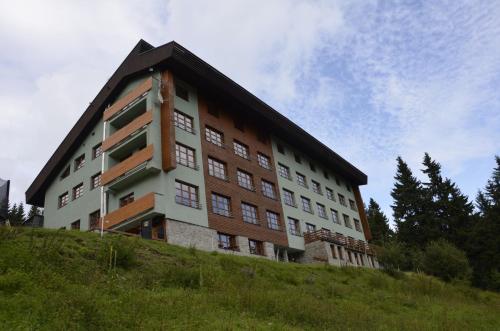 a building on top of a grassy hill at Apartmán v Srdci Hor Cihlářka in Pec pod Sněžkou