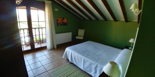 a green bedroom with a bed and a window at Apartamentos Antonio in Ubiarco