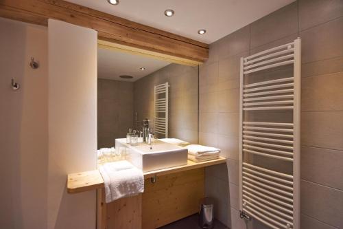 uma casa de banho com um lavatório e um espelho em La Foyère em Aime La Plagne