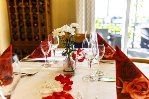 a table with wine glasses and flowers on it at Hotel Rheingold in Gernsheim