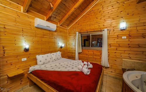 sypialnia z łóżkiem w drewnianym domku w obiekcie Chalet The Mountain To The Sea w mieście Beẕet