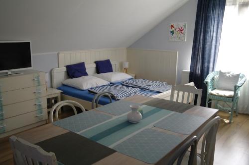 - une chambre avec un lit, une table et des chaises dans l'établissement Nóra Apartman, à Gyula