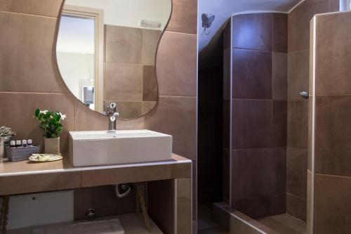 a bathroom with a sink and a mirror at Portes Houses in Koufonisia