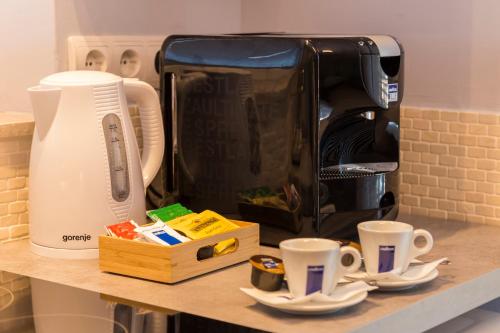 a counter with two coffee cups and a toaster at H49 Apartman Wellness & Spa - Adults only in Sovata