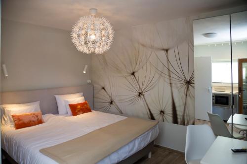 a bedroom with a large bed with a chandelier at H49 Apartman Wellness & Spa - Adults only in Sovata