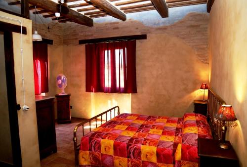a bedroom with a bed and red curtains in a room at B&B Mik e Ramo in Abbadia di Fiastra
