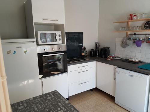 une cuisine avec des armoires blanches et un micro-ondes dans l'établissement Proche chateau, à Muides-sur-Loire