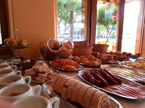a table topped with plates of breakfast foods and coffee at Hotel Filoxenia in Nei Poroi