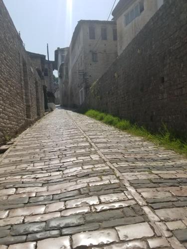an empty street in an alley between two buildings at Lori's traditional house in Gjirokastër
