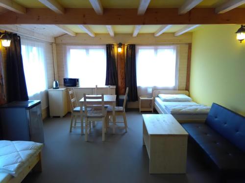 a room with two beds and a table and chairs at Penzion U Rozcesti in Lančov