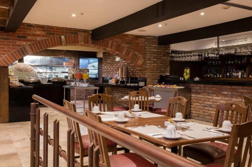 un ristorante con tavolo, sedie e un bar di Krystal Urban Aeropuerto Ciudad de Mexico a Città del Messico