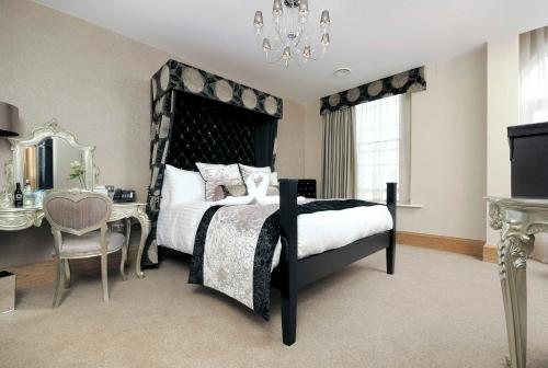 a bedroom with a bed and a table and a chair at Ennios Boutique Hotel in Southampton