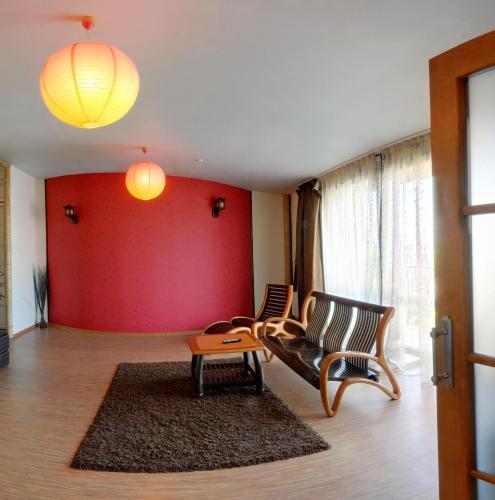 a living room with two chairs and a red wall at Tsentralniy Hotel in Khmelʼnytsʼkyy