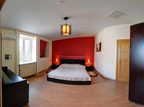 a bedroom with a bed and a red wall at Tsentralniy Hotel in Khmelʼnytsʼkyy