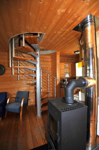 a woodburning stove in a room with a staircase at Feriendorf Tauerngast in Hohentauern